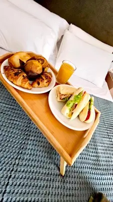 two plates of food on a tray on a bed at Erofili central apartment in Chania Town