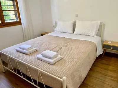 a bedroom with a bed with two towels on it at Charming house 8 minutes walk from Almyrida beach in Almirida