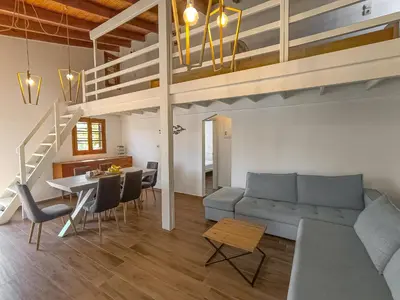 a living room with a couch and a dining room at Charming house 8 minutes walk from Almyrida beach in Almirida