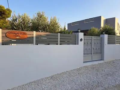 a white fence in front of a building at Gramvousa's Hidden Gem in Áyios Yeóryios