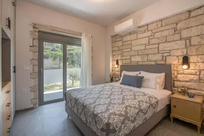 a bedroom with a bed and a brick wall at Gramvousa's Hidden Gem in Áyios Yeóryios