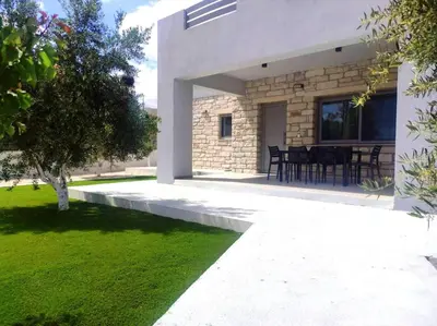 a view of a house with a patio and grass at Gramvousa's Hidden Gem in Áyios Yeóryios
