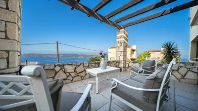 a patio with chairs and a table with a view at Villa Majestic Crete heated pool and sauna in Megála Khoráfia