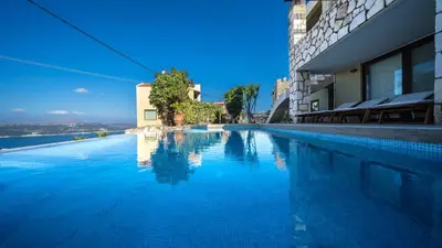 a swimming pool with blue water next to a building at Villa Majestic Crete heated pool and sauna in Megála Khoráfia