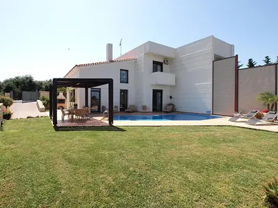 a white house with a yard with a pool at VILLA ROTUNDA B in Chania Town