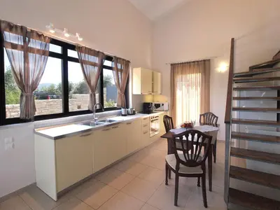 a kitchen with a sink and a table with chairs at VILLA ROTUNDA B in Chania Town