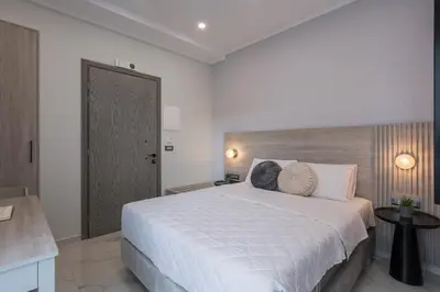 a bedroom with a large white bed with two pillows at Alexia Seaview Apartments in Kissamos