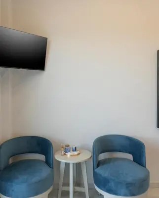 two blue chairs and a table in a room at Alexia Seaview Apartments in Kissamos
