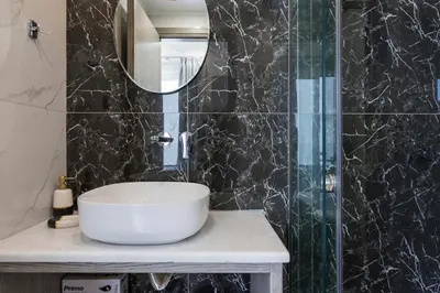a bathroom with a sink and a glass shower at Alexia Seaview Apartments in Kissamos