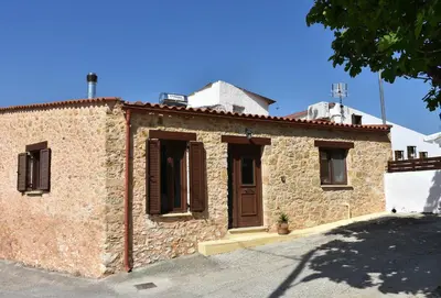 a brick building with a door and windows at ESTIA stone house in Vrísai