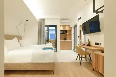 a bedroom with a bed and a desk and a television at Orfeas Apartment in Chania Town