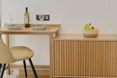 a table with two glasses of wine and a basket of fruit at Orfeas Apartment in Chania Town