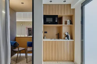 a room with a kitchen with a microwave and a table at Orfeas Apartment in Chania Town