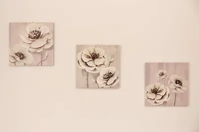 three pictures of flowers on a white wall at Sylvias Stylish Apartment in Chania Town