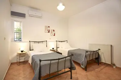 a bedroom with two beds and a window at Sylvias Stylish Apartment in Chania Town