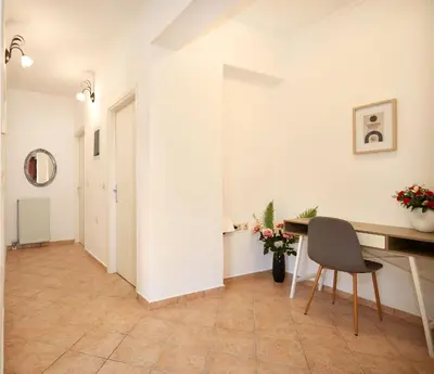 a hallway with a desk and a chair in a room at Sylvias Stylish Apartment in Chania Town
