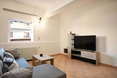 a living room with a large flat screen tv at Sylvias Stylish Apartment in Chania Town