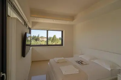 a white bedroom with a bed and a window at Luxury Villa Glass - 200 meters From The Beach no6 in Daratso