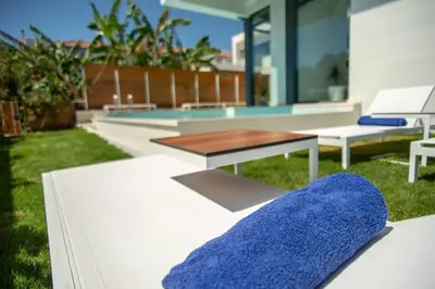 a bench with a blue pillow on a patio at Luxury Villa Glass - 200 meters From The Beach no6 in Daratso