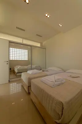 a bedroom with two beds and a large mirror at Luxury Villa Glass - 200 meters From The Beach no6 in Daratso
