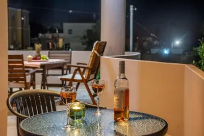 a bottle of wine sitting on a table with two glasses at Casa Anthea 3 bedroom apartment with Garden in Kounoupidhianá