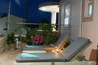 a patio with a table and chairs on a balcony at Casa Anthea 3 bedroom apartment with Garden in Kounoupidhianá