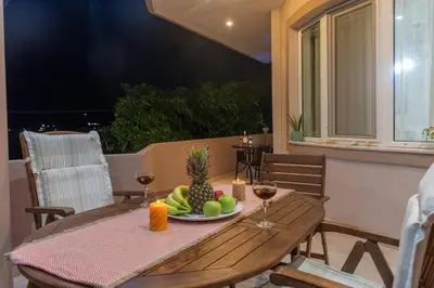 a wooden table with a plate of fruit and wine glasses at Casa Anthea 3 bedroom apartment with Garden in Kounoupidhianá