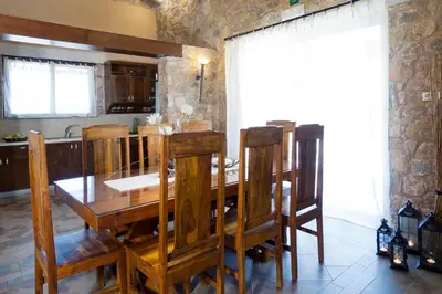 a kitchen with a wooden dining room table and chairs at Villa Litsarda in Litsárdha