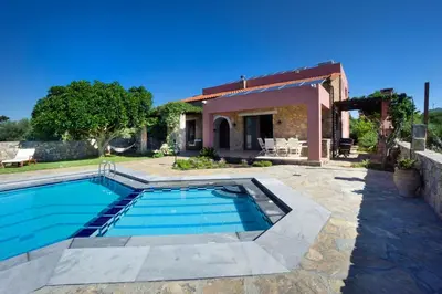 a villa with a swimming pool in front of a house at Villa Litsarda in Litsárdha
