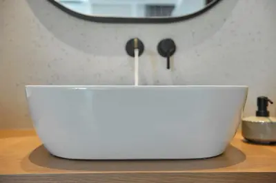 a white bowl sitting on a table with a mirror at Evridiki Apartment in Chania Town