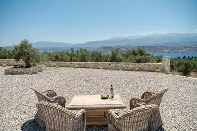 a table with a bottle of wine and two chairs at Sunny Vacay Villa in Stérnai