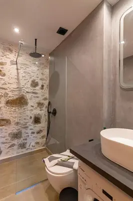 a bathroom with a toilet and a sink and a shower at Plagia Rooms in Kissamos