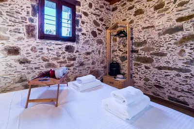 a room with a bed with a mirror and a table at Plagia Rooms in Kissamos