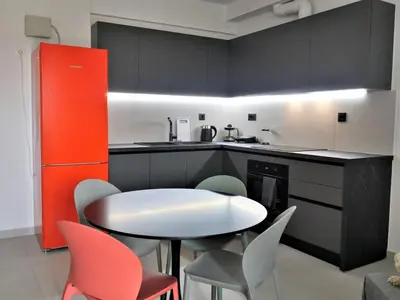 a kitchen with a white table and chairs and a red cabinet at Hellene Αpartment near Chania City Centre in Chania Town