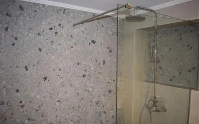 a shower with a stone wall in a bathroom at Renia's house in Daratso