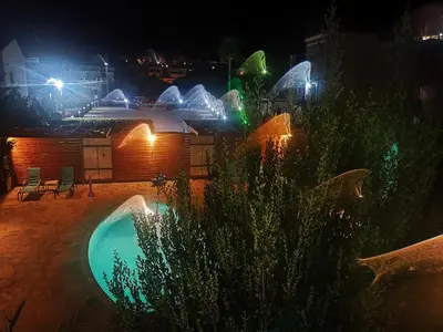 a resort with a swimming pool at night at Almiris Seaside Apartments in Almirida