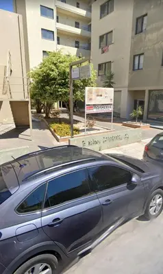 a car parked in a parking lot in front of a building at Luxury apartment in the heart of the city in Chania Town