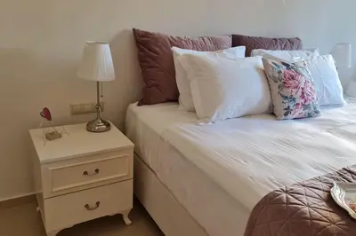 a bed with pillows and a night stand with a lamp at Luxury apartment in the heart of the city in Chania Town