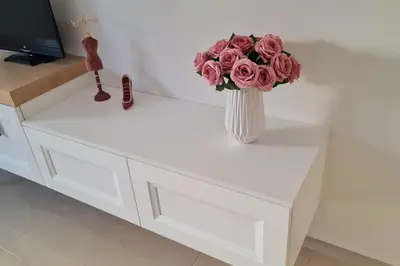 a vase with pink roses sitting on a white table at Luxury apartment in the heart of the city in Chania Town