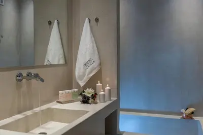 a bathroom with a tub and a sink with two candles at Serenissima Boutique Hotel in Chania Town
