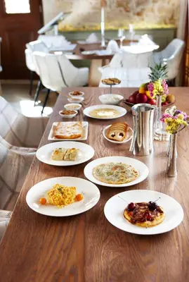 a long wooden table with plates of food on it at Serenissima Boutique Hotel in Chania Town