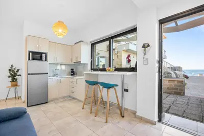 a kitchen with a counter and stools in a room at Celeste Junior Suite on the Beach in Agia Marina Nea Kydonias