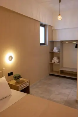 a bedroom with a bed and a desk and a window at Celeste Junior Suite on the Beach in Agia Marina Nea Kydonias