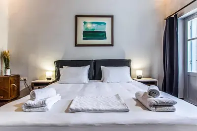 a bedroom with a white bed with towels on it at Casa Ari - Venetian Port in Chania Town