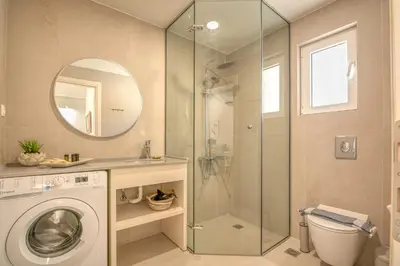 a bathroom with a washing machine and a mirror at Koutris Apartment 2 in Falasarna
