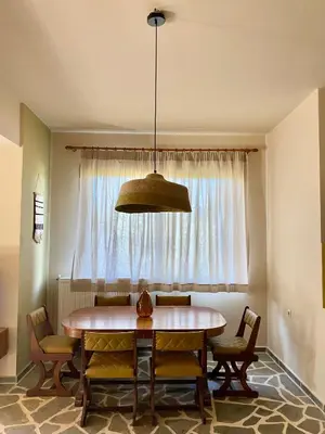 a dining room with a table and a window at The Leaf House in Varípetron