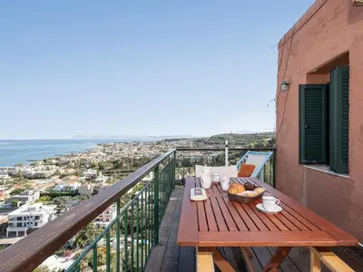 a table on a balcony with a view of the ocean at The Hillside Home in Plataniás