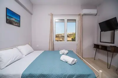 a bedroom with a large bed with towels on it at Sea Gem family in Chania Town