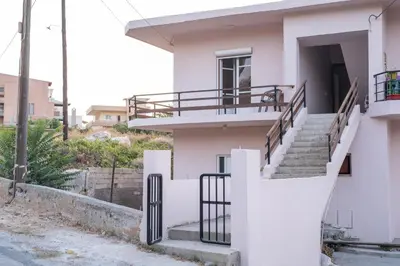 a white house with stairs and a balcony at Sea Gem family in Chania Town