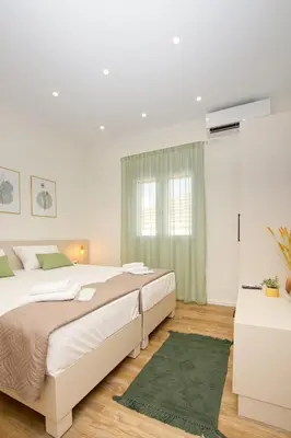 a bedroom with two beds and a green rug at Callisto House in Kalyves in Kalyves